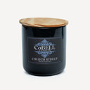 Black candle jar with wooden lid and Cobell Candles label on a white background